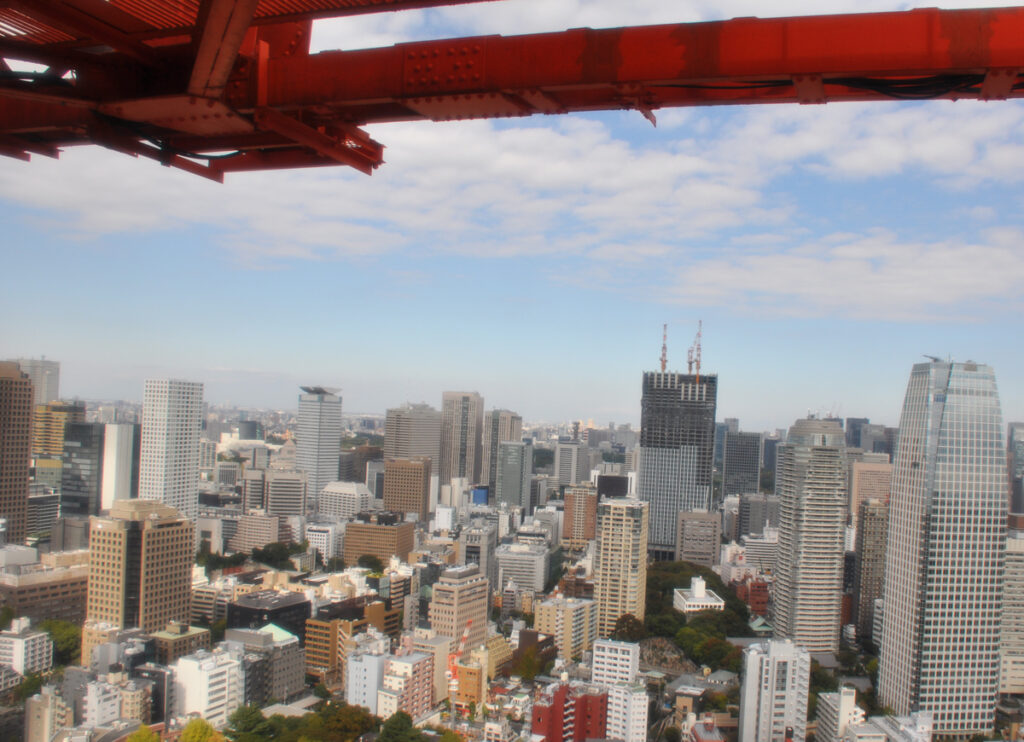 展望台から視線を落とせば、風景は一変する。 足元に広がる芝公園の深い緑。 その境界線を断ち切るように、鏡面仕上げの超高層ビルが屹立する。 麻布台ヒルズ、虎ノ門の摩天楼。